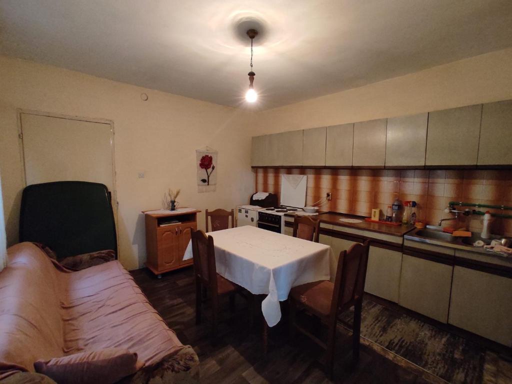 a kitchen with a table and a white table and chairs at Sremac in Kupinovo