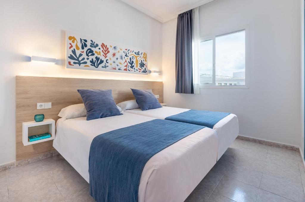 a bedroom with a large bed and a window at Hotel Apartamentos Vibra Lux Mar in Ibiza Town