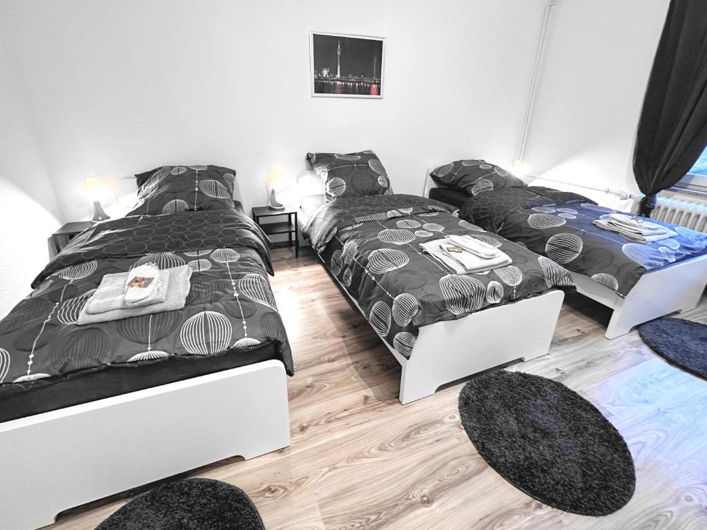 een slaapkamer met 2 bedden en 2 tapijten bij # VAZ Apartments RS05 TV, WLAN, Küche, Zentrumsnah in Remscheid