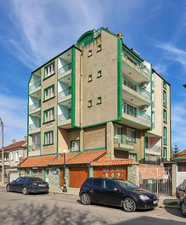 a building with two cars parked in front of it at Къща за гости Бор in Pomorie