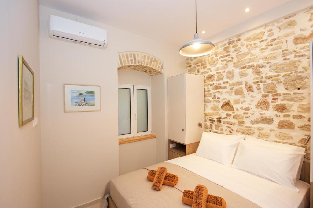 een slaapkamer met een bed en een stenen muur bij Galiello Boutique Suite by Corfuescapes in Corfu-stad