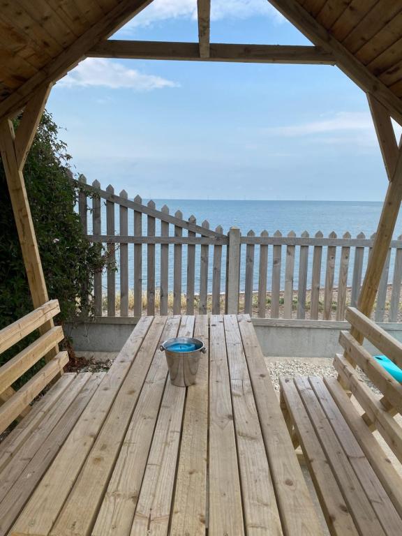 a wooden table with a bucket on the beach at BRiSYL BEACH HOUSE, with amazing changing views! in Kent