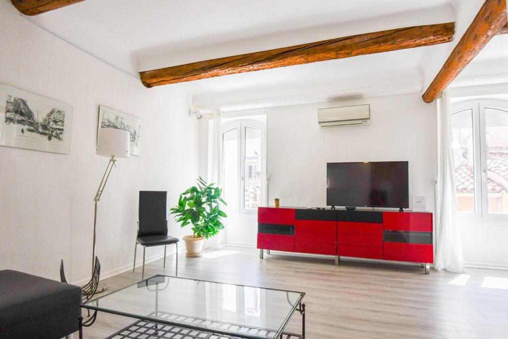 - un salon avec une armoire rouge et une télévision dans l'établissement Appart 2 ch AC proche Cours Julien & Vieux-Port, à Marseille