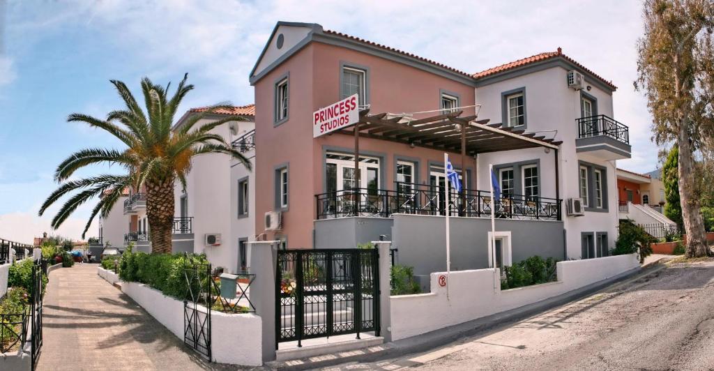 a house on a street with a palm tree at Princess Studios Mitilini in Mytilene