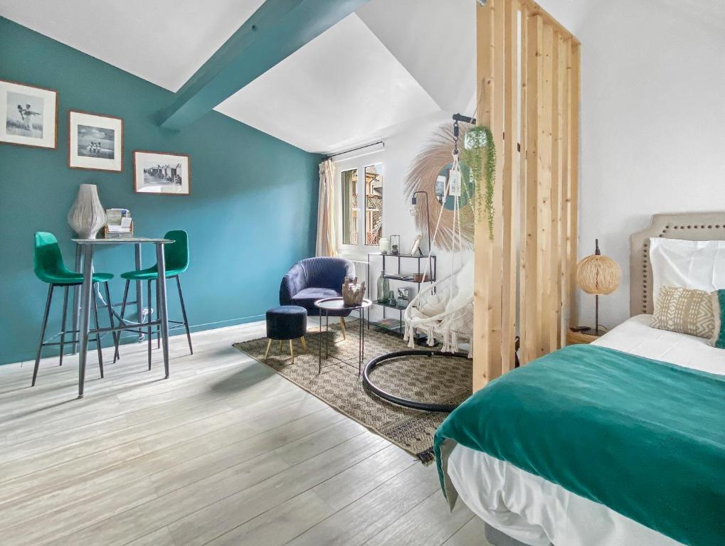 1 dormitorio con paredes azules, 1 cama y escritorio en Les Calins d'Honfleur, en Honfleur
