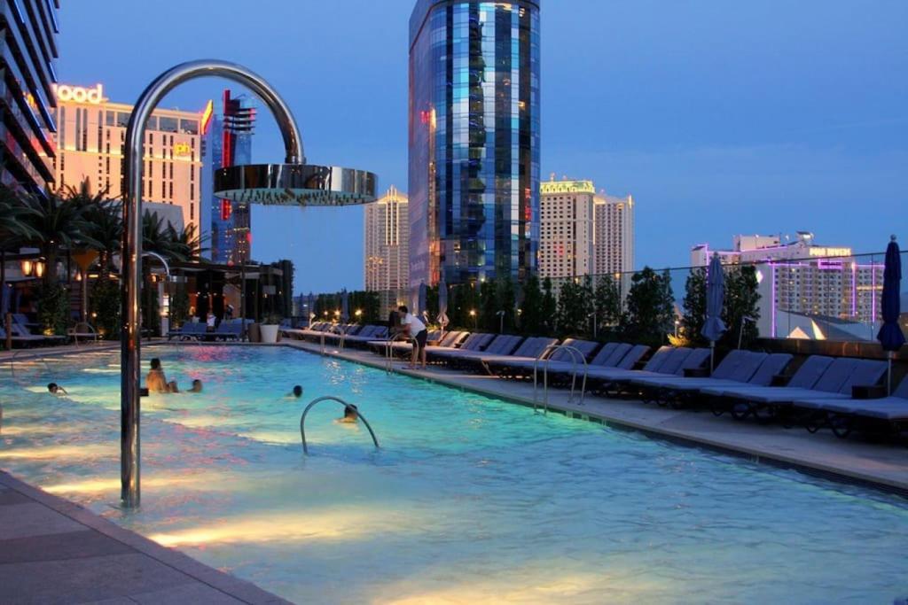 a swimming pool with people in a city at night at ON THE STRIP - Classic Comfort - 2 Bedroom Condo in Las Vegas