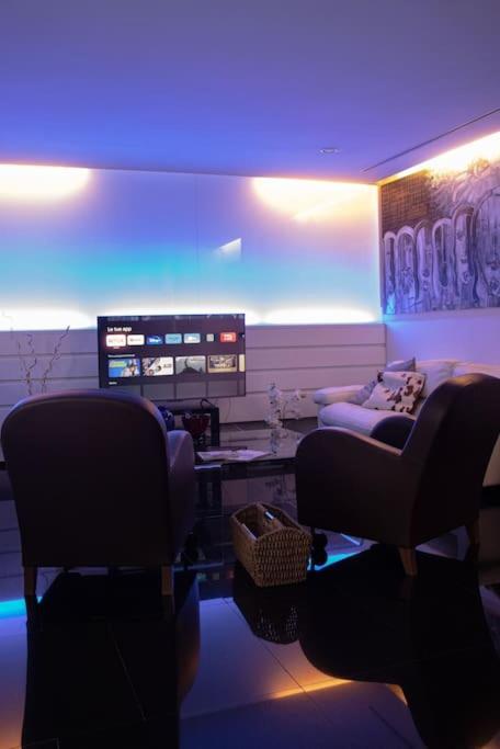 a living room with blue lighting and couches and chairs at Luxury suite 2 min dal Politeama - Free Parking in Palermo