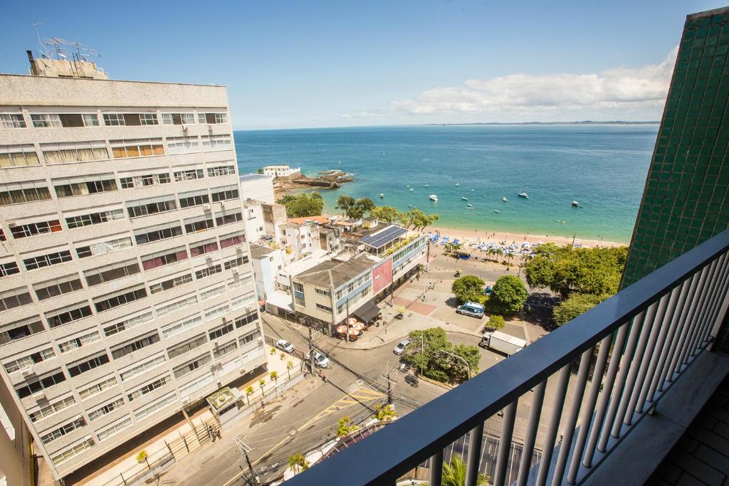 uma vista para a praia a partir da varanda de um edifício em Rede Andrade Barra em Salvador