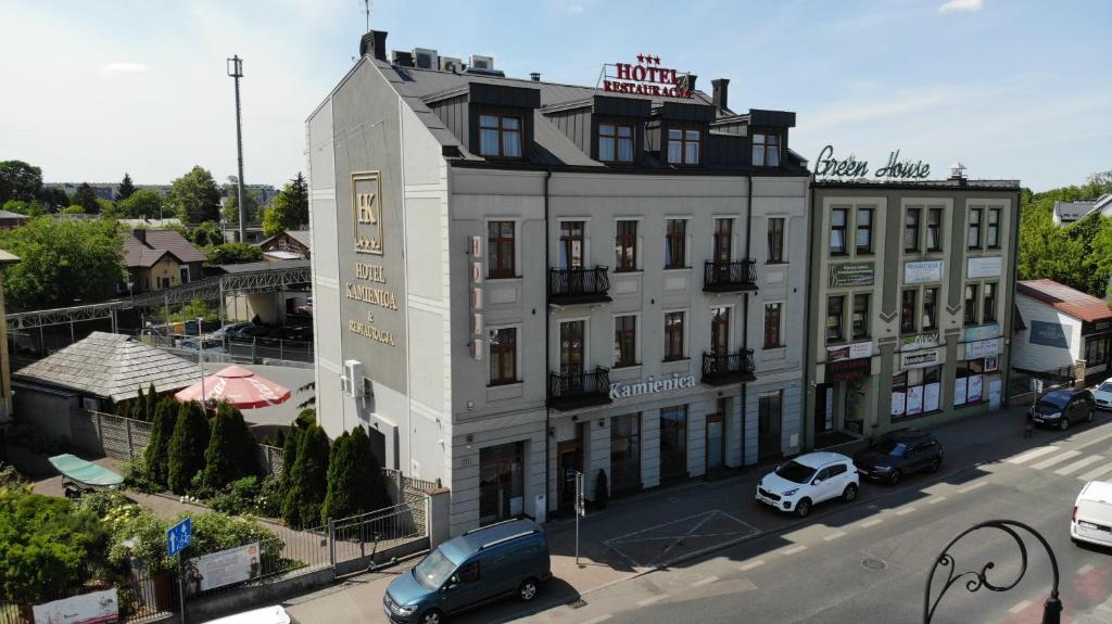 un edificio blanco con coches estacionados frente a él en Hotel Kamienica, en Siedlce
