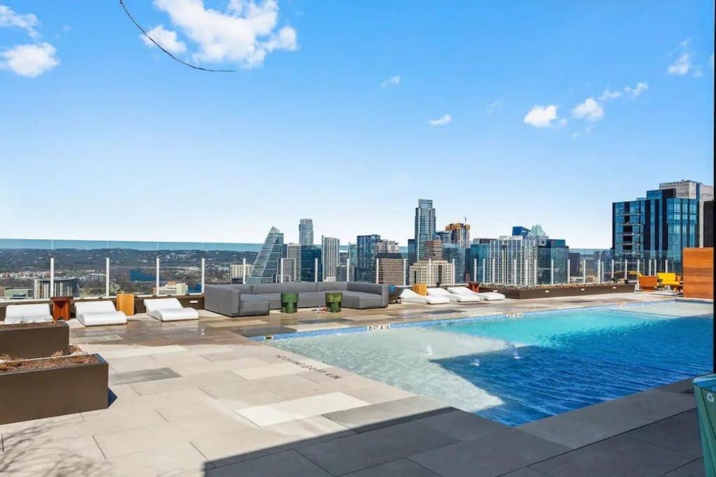a swimming pool on the roof of a building with a city at Luxury 1BR - Rainey St - Top Amenities - RoofTop Pool - 11th Floor in Austin