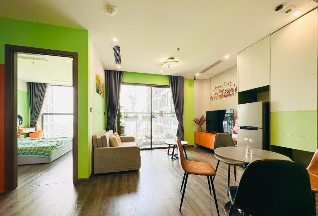 uma sala de estar com paredes verdes e uma mesa em Siro House- Homestay cao cấp Vinhomes Ocean Park, Gia Lâm em Hanói