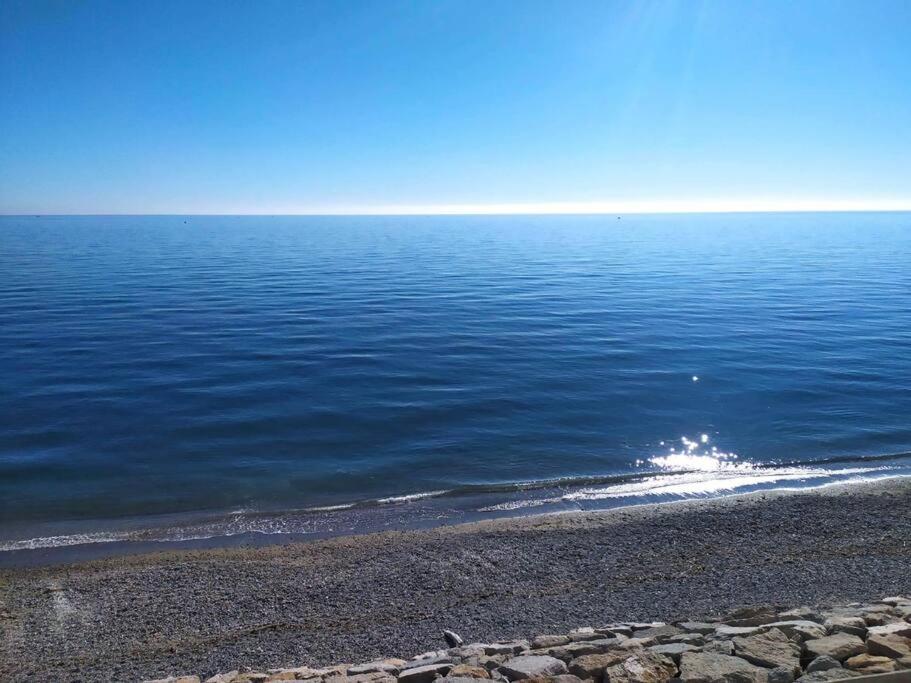 un gran cuerpo de agua con una playa rocosa en Beachfront apartment en Estepona