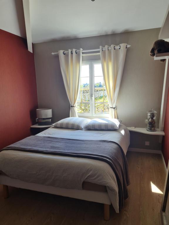 a bedroom with a large bed with a window at Entre Loire et Vignobles in Liré