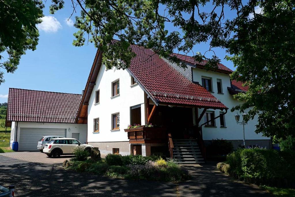 een groot wit huis met een rood dak bij Ferienhof Zum Rössberg in Geisa