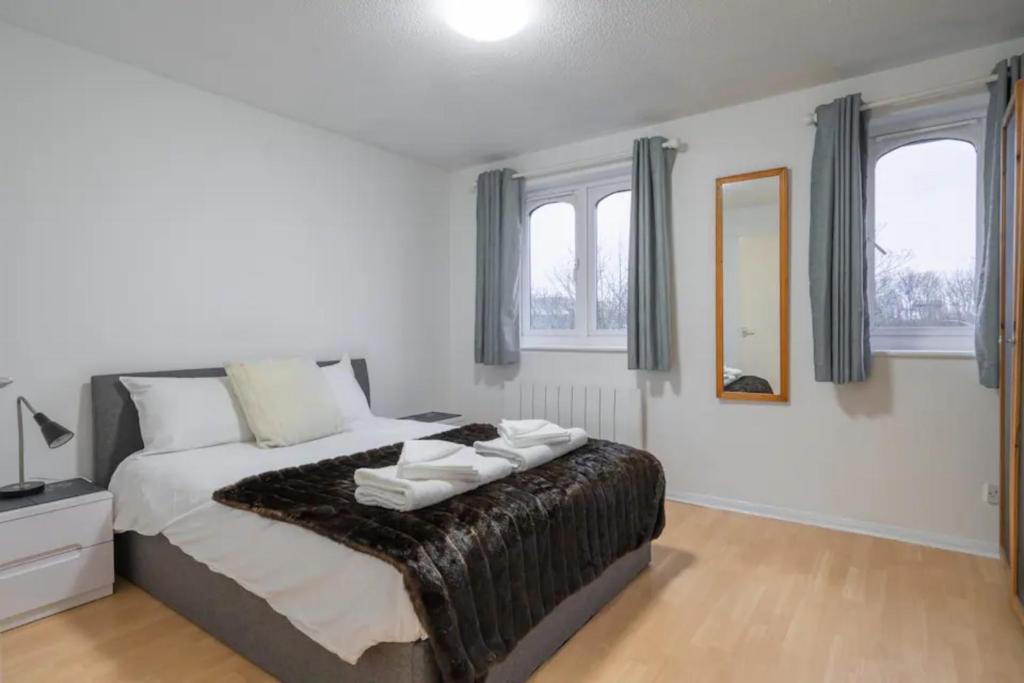 1 dormitorio con 1 cama con toallas en 1BD Flat - Prime Location Surrey Quays, en Londres