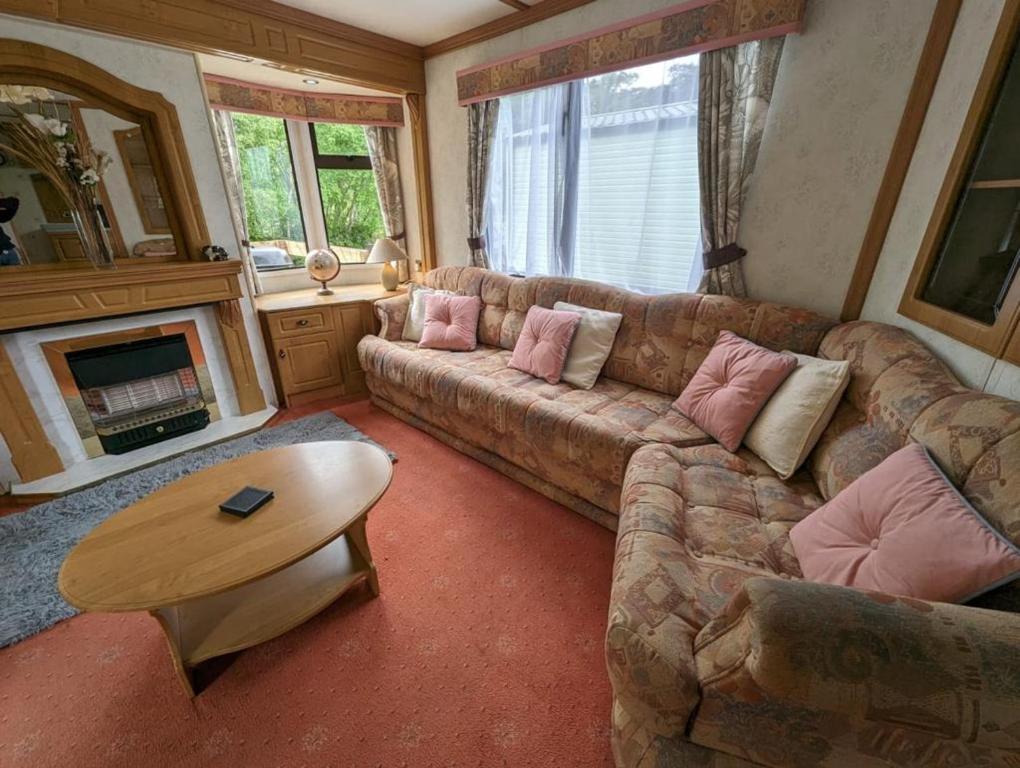 a living room with a couch and a table at 55 Glenfinart Caravan Park in Dunoon