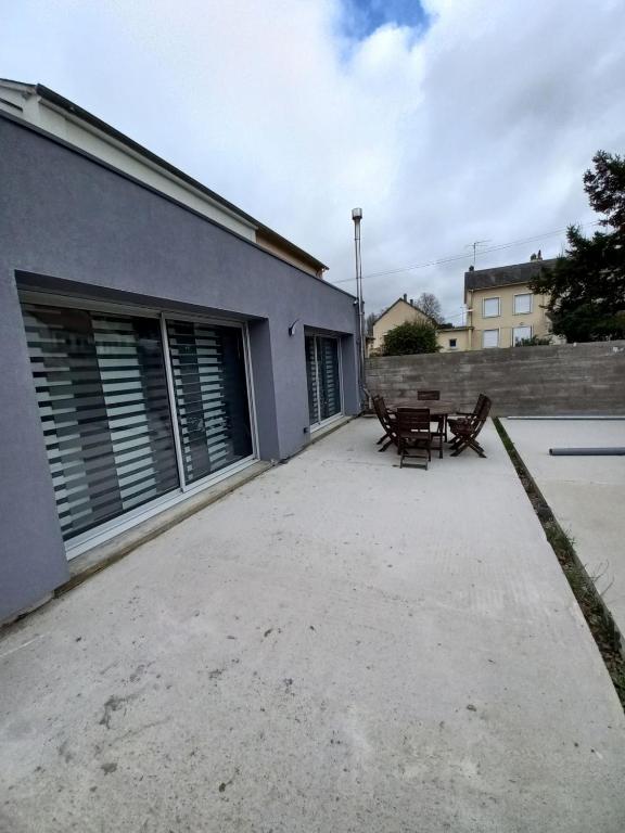un patio avec une table et un banc à côté d'un bâtiment dans l'établissement Magnifique maison à 5 mns du circuit des 24h à pieds, au Mans