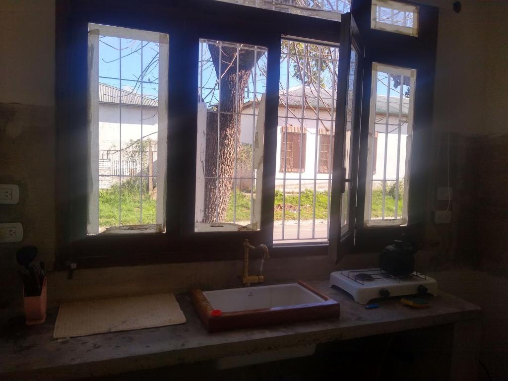 cocina con fregadero y 3 ventanas en La casita de Armi en Gualeguaychú