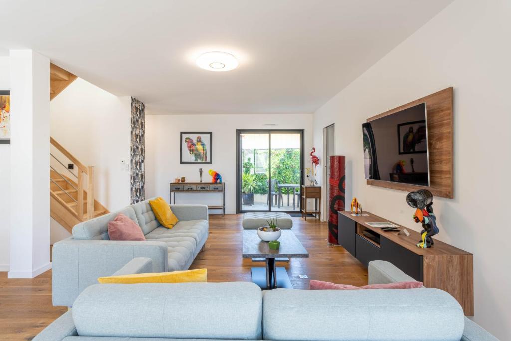 un salon avec deux canapés et une télévision dans l'établissement Banana Beach - Magnifique Villa contemporaine vue mer plage à 20 m avec paddles, à Sarzeau