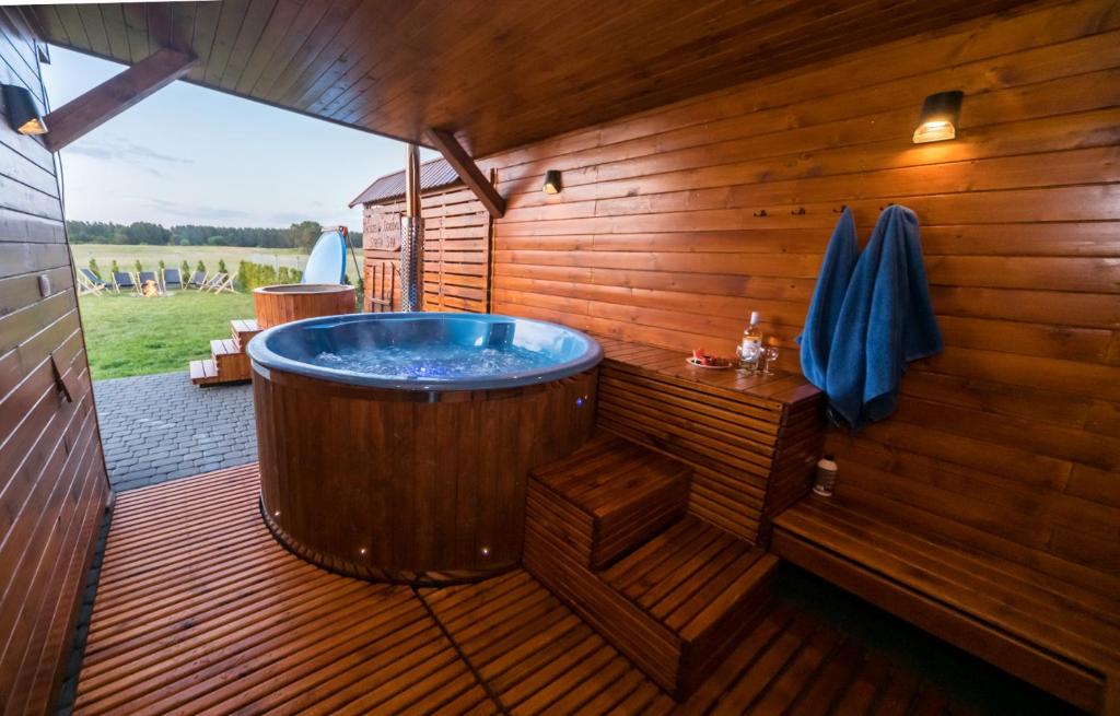 a large wooden bath tub in a wooden deck at ZACISZE W OGRÓDKU Dom z balią i sauną in Ogródek