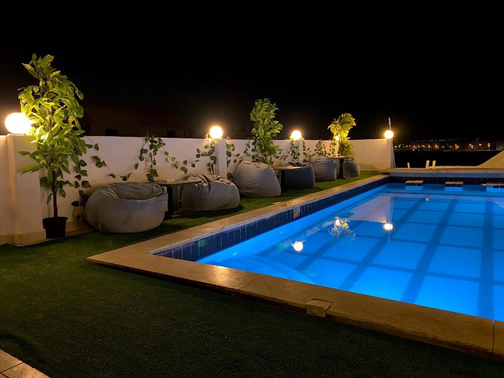 una piscina por la noche con luces en La Boutique Residence, en Hurghada