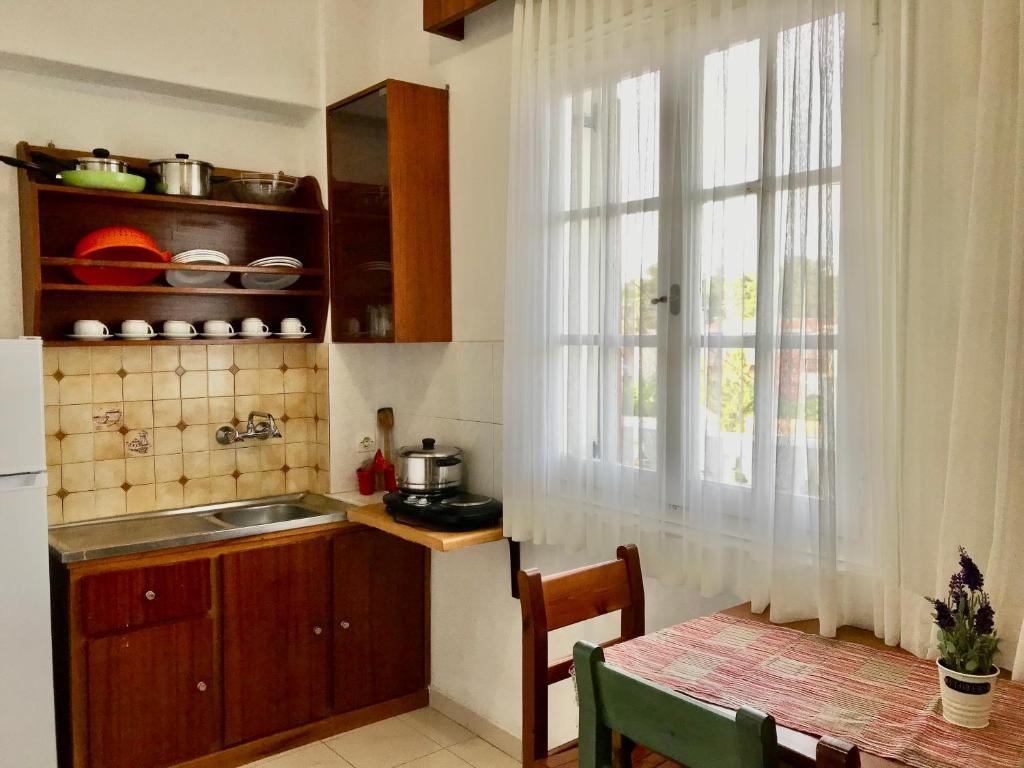 una cucina con lavandino, finestra e tavolo di Dionysos Studios a Laganas