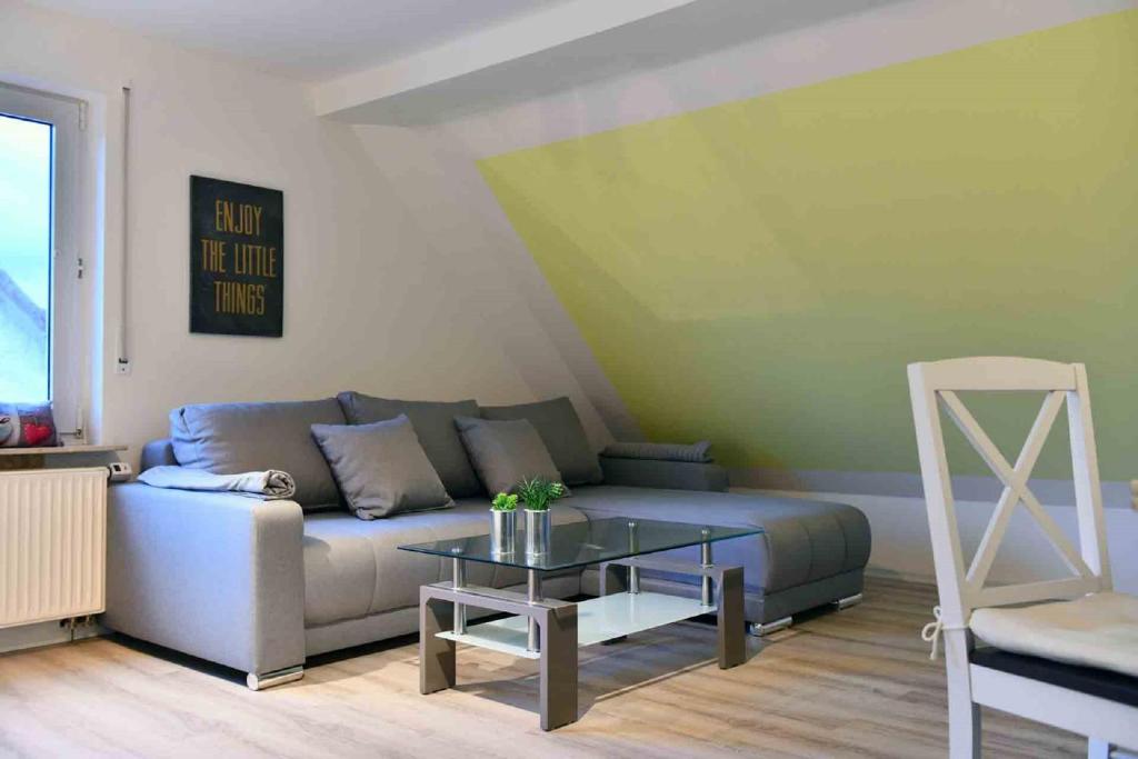 a living room with a couch and a glass table at Ferienwohnung über den Dächern von Oberelsbach in Oberelsbach
