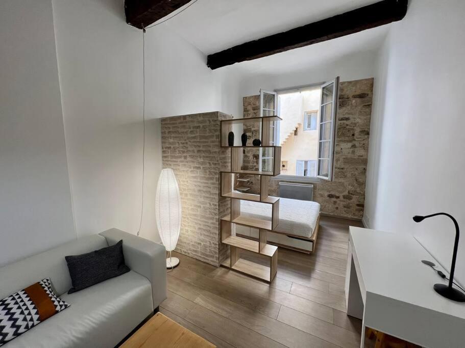 uma sala de estar com um sofá branco e uma cadeira em Le Multipliant em Montpellier