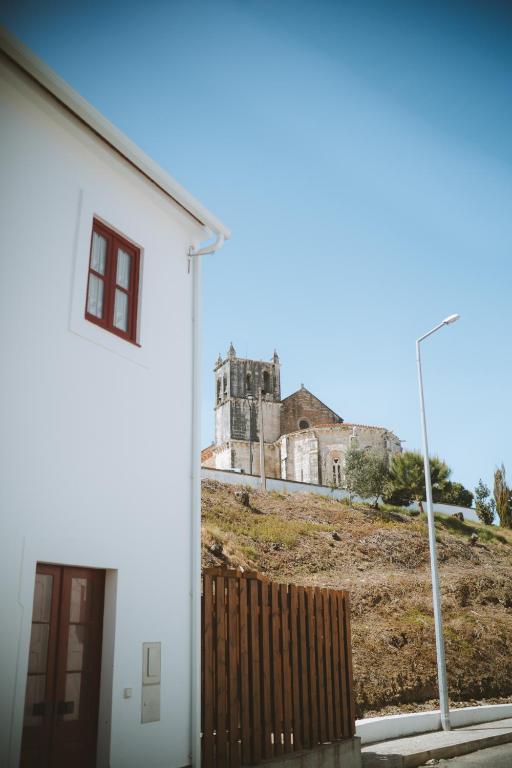 a white building with a castle in the background at Casita do Castelo in Lourinhã