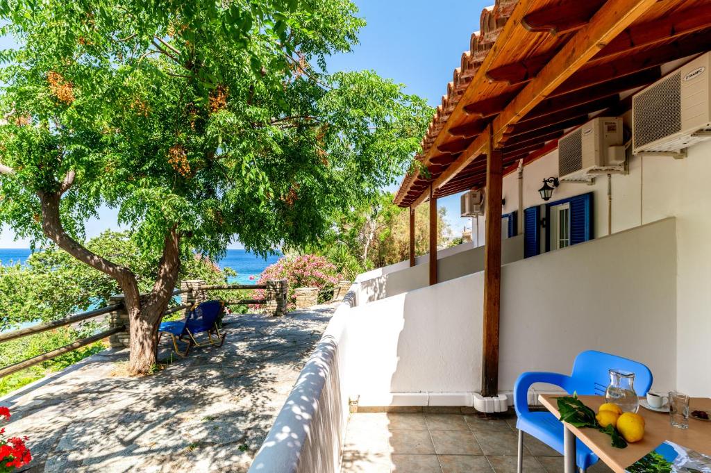 a house with a table and chairs and a tree at Seaview Mastrozanne Studio 9 Andros in Andros
