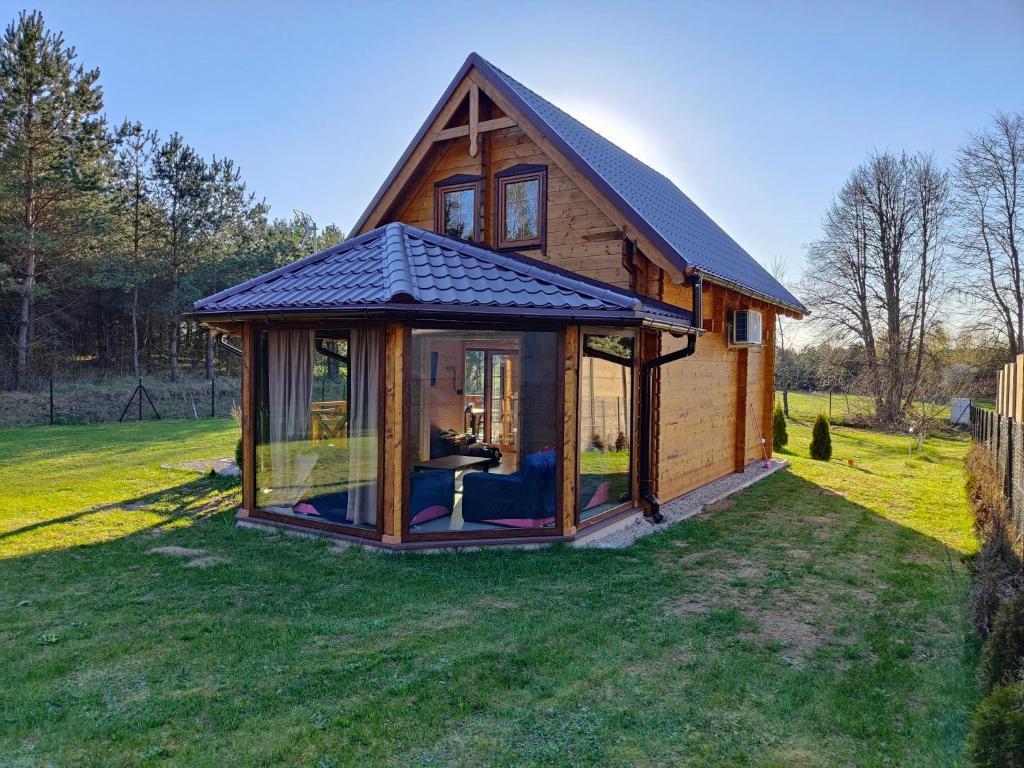 ein kleines Haus mit einem großen Fenster im Hof in der Unterkunft DOMEK AGA in Kruklanki