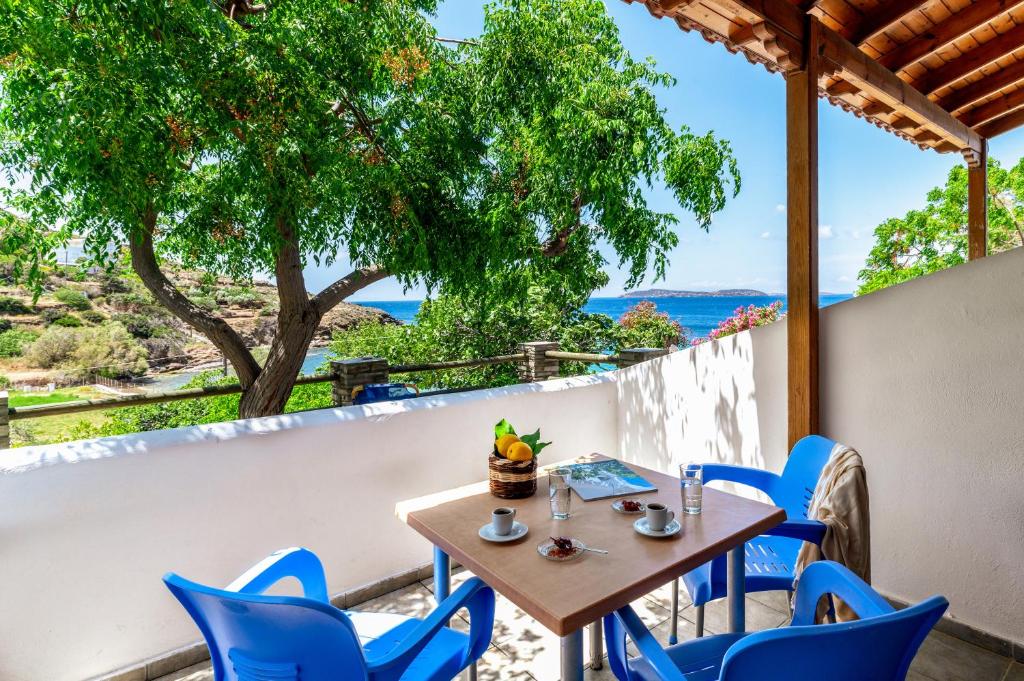 a table and chairs on a balcony with a view of the ocean at Seaview Mastrozanne Studio 8 Andros in Andros