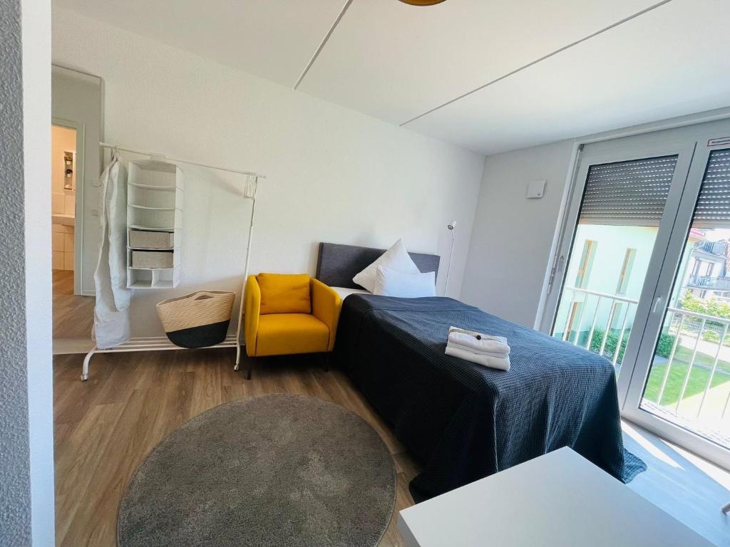 a bedroom with a bed and a yellow chair at City - Business - Appartement in Bielefeld