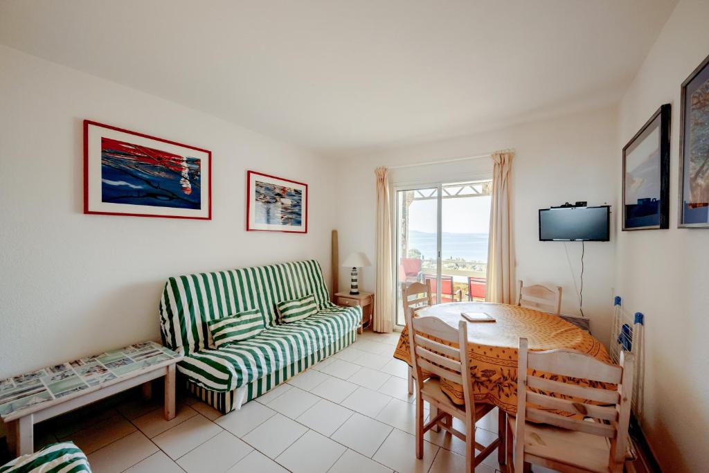 uma sala de estar com um sofá e uma mesa em Origan - Appt pour 4 voyageurs et splendide vue mer em Le Lavandou