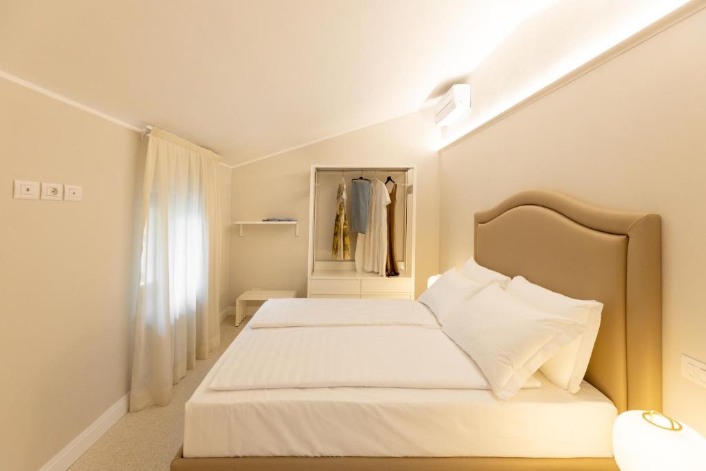 a white bedroom with a bed and a closet at Casa Carmela Apartments in Bardolino