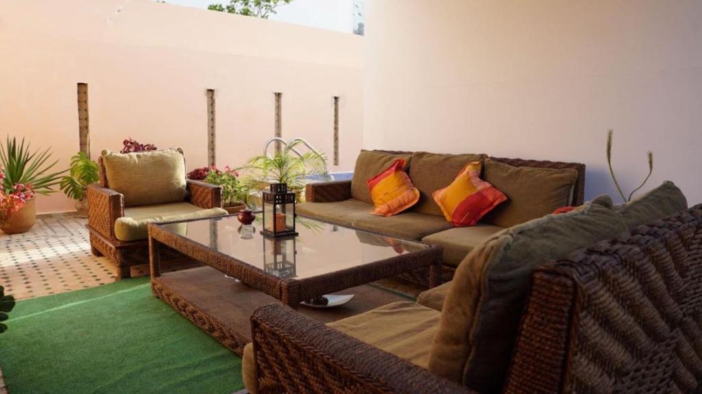 a living room with couches and a coffee table at riad casa bahia asilah in Asilah