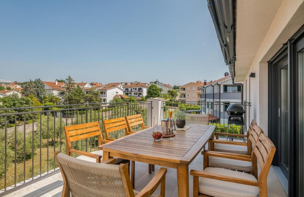 a wooden table and chairs on a balcony with a view at Apartment Marko in Malinska