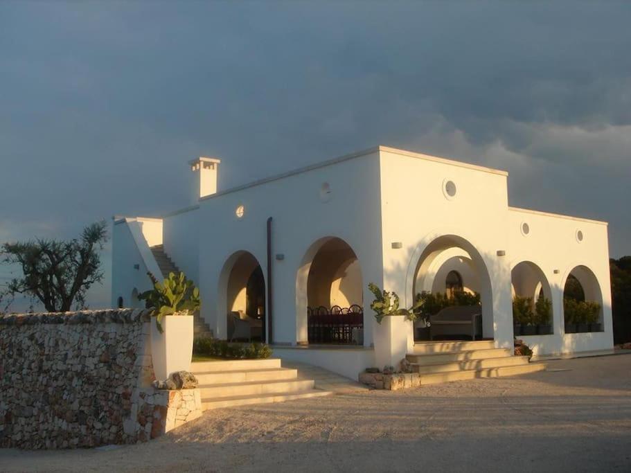 een wit gebouw met bogen en trappen ervoor bij Tenuta Sicilia in Ostuni