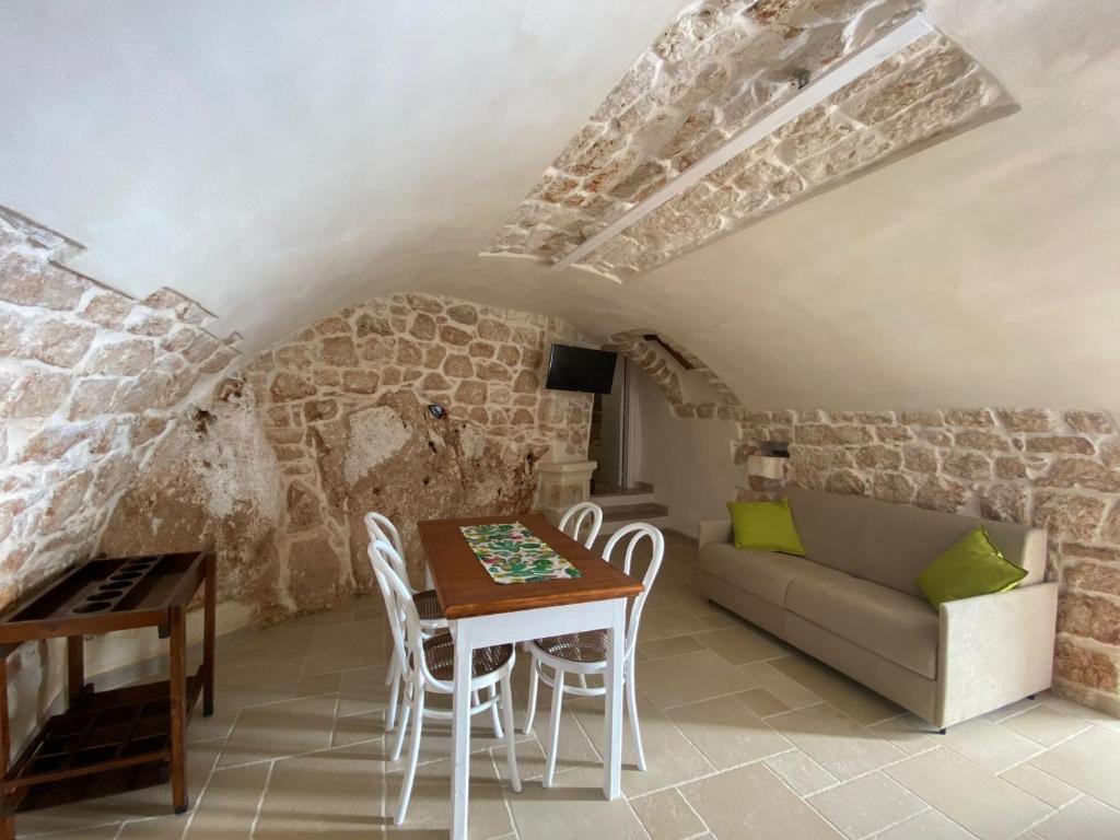ein Wohnzimmer mit einem Sofa und einem Tisch in der Unterkunft Angolo nella Roccia in Ostuni