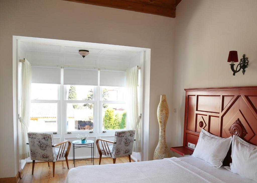 a bedroom with a bed and a table and a window at Alacati Gubiba Evleri in Alaçatı