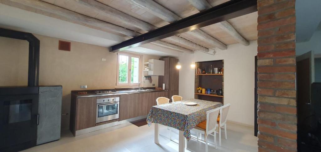 y cocina con mesa, sillas y fogones. en Casa vacanze Tredis, en Nogaredo di Prato
