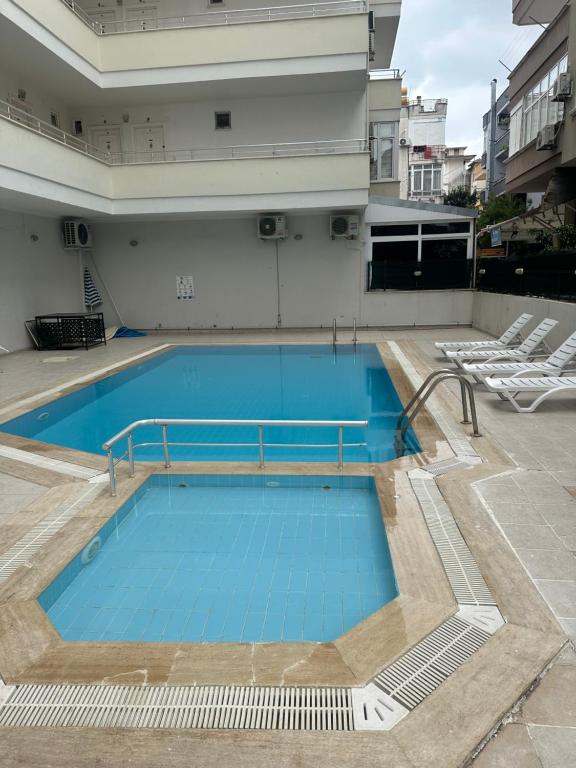 uma grande piscina com cadeiras num edifício em Best Home City 1 em Alanya