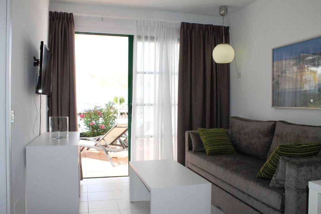 a living room with a couch and a table at Apartamentos Babalu in Puerto Rico de Gran Canaria