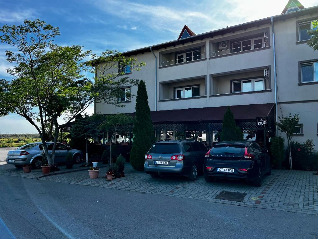 dos coches estacionados frente a un edificio en Hanul Kartali en Lumina