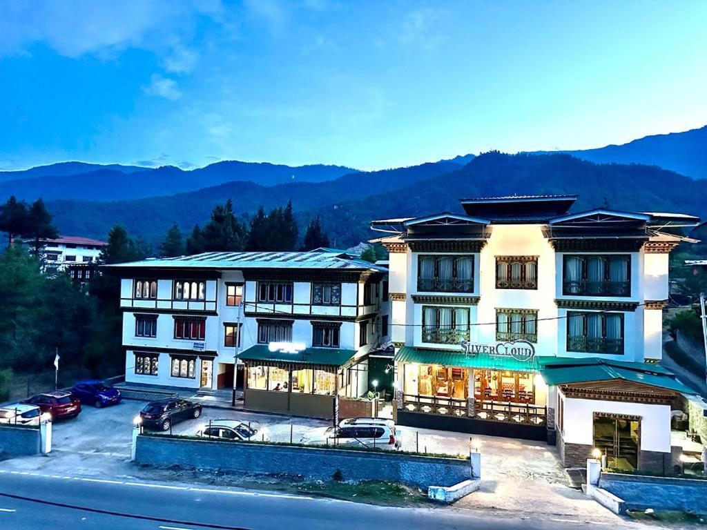 un gran edificio con coches estacionados en un estacionamiento en Silver Cloud Hotel en Paro