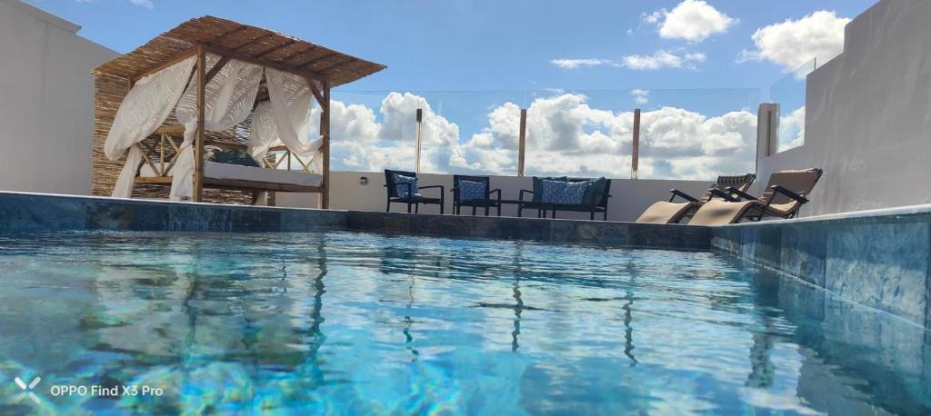 a swimming pool with chairs and a gazebo at FAMILY HOME WITH POOL, Fuerteventura-Gran Tarajal in Juan Gopar