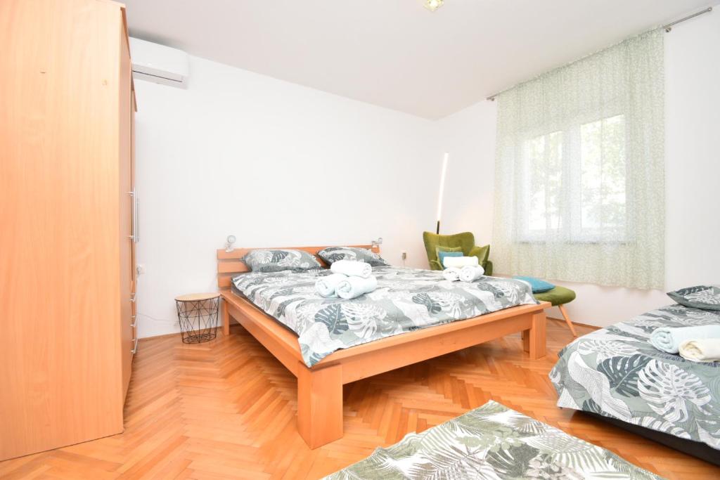 Un dormitorio con dos camas y suelo de madera. en Helena House Bibinje, en Bibinje