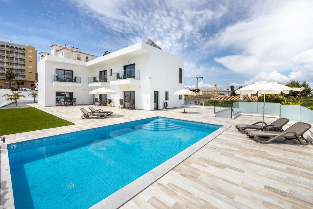 a villa with a swimming pool and a house at CASA DAS PRAIAS in Lagos
