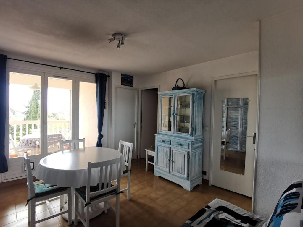 une salle à manger avec une table et un meuble bleu dans l'établissement Deux pièces avec vue mer, à Fréjus