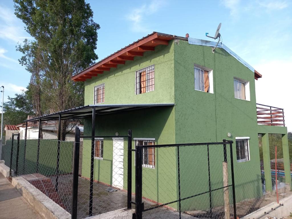 a green house with a fence in front of it at Solanas tanti in Tanti